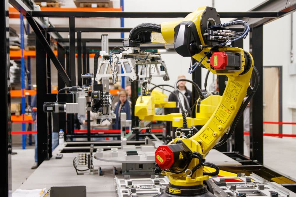 A yellow industrial robot arm on an automated production line