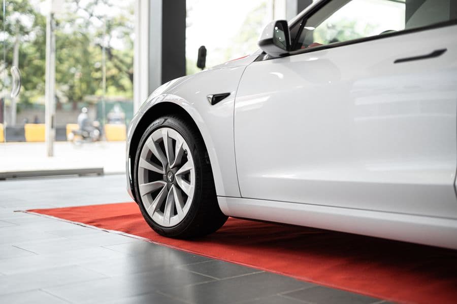 A white electric car on display in a bright showroom