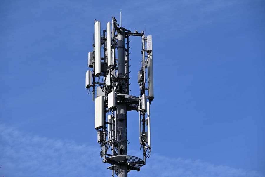 A telecommunications mast with antennas against a blue sky