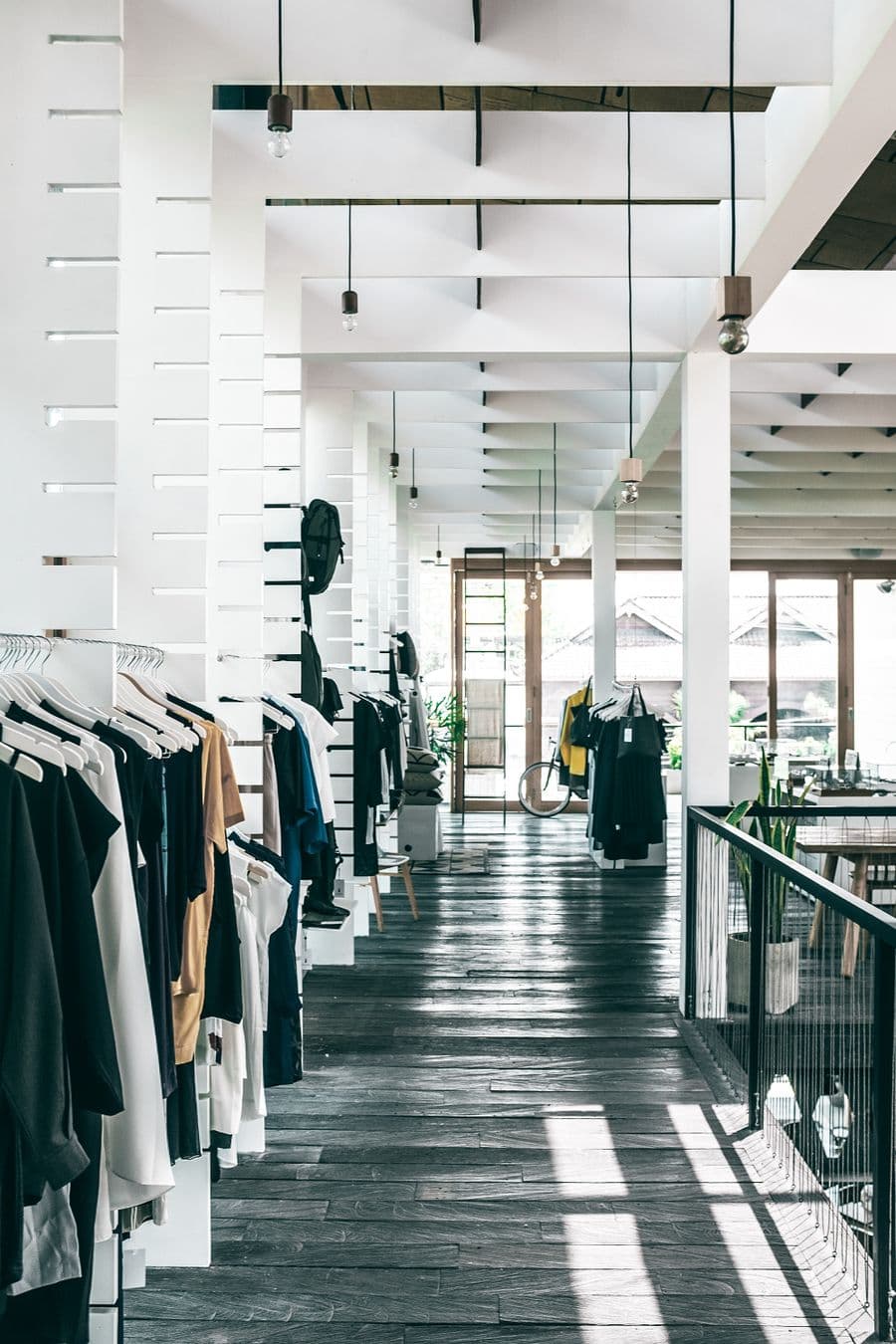 A bright retail store interior with clothing racks