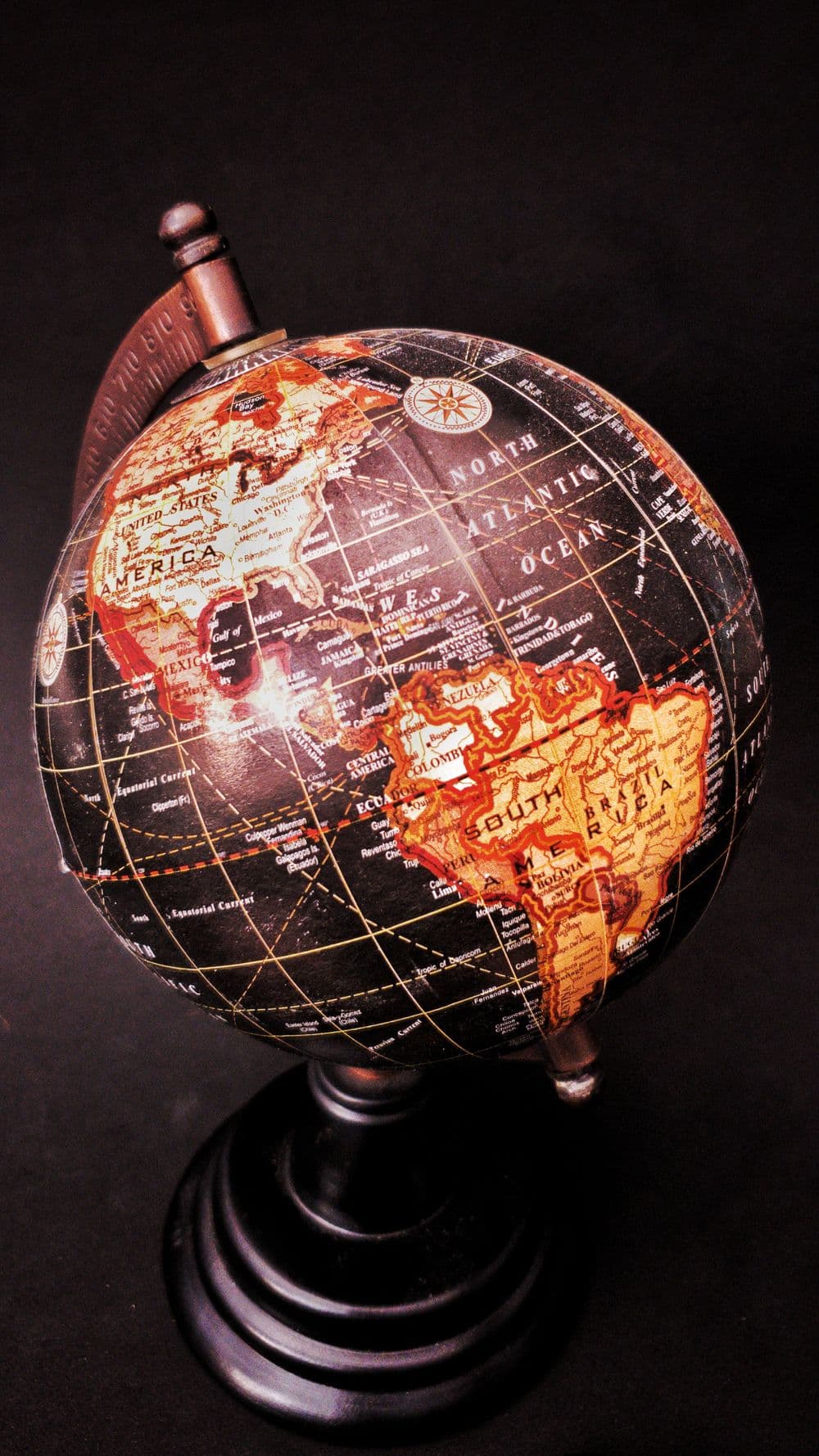 A vintage globe showing the Americas against a dark background