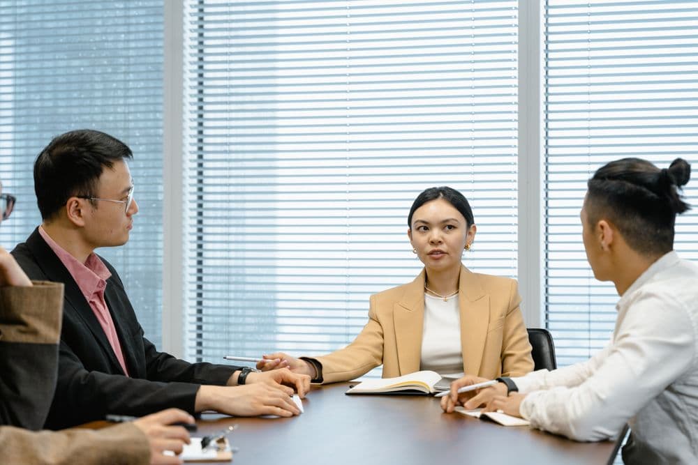 Business colleagues discussing documents around a meeting-room table